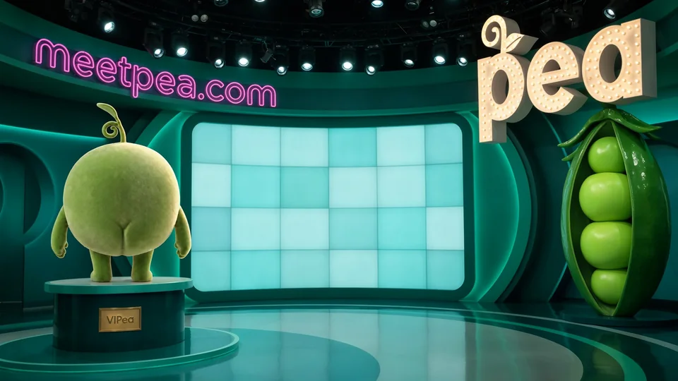 A television studio set with a lit pea sign and a Pea statue